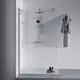 Duschsystem mit einem Wandpaneel und einem Brausethermostat in Chrom, daneben hängt ein grauer Bademantel. Unter dem Duschbereich stehen Pflegeprodukte auf einem Tablett. Ideal Standard.